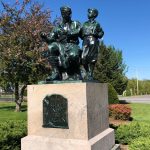 The official Peace Statue of the Commonwealth of Massachusetts with a man kneeling next to a boy.